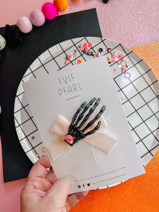 Spooky black skelly hand light pink bow