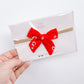 Small red floral bow on nylon headband
