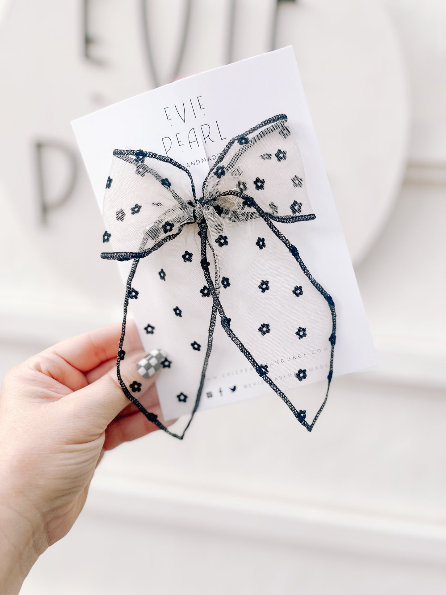 Close up of black sheer daisy flocked bow oversized 5x6 inch hair accessory with floral details

