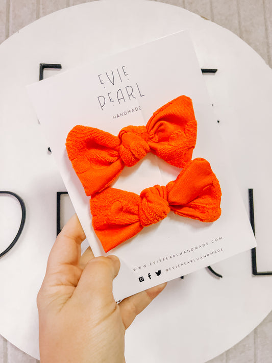 Orange Swiss knot bow pigtails