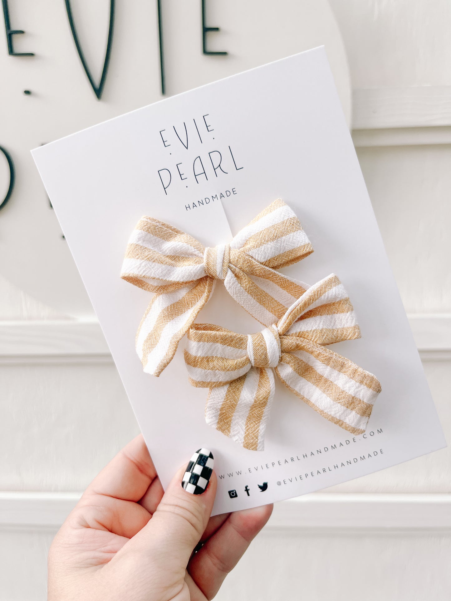 Close-up of cream and yellow striped pinwheel bows – 2 x 3 inches with right and left alligator clips and teeth grip