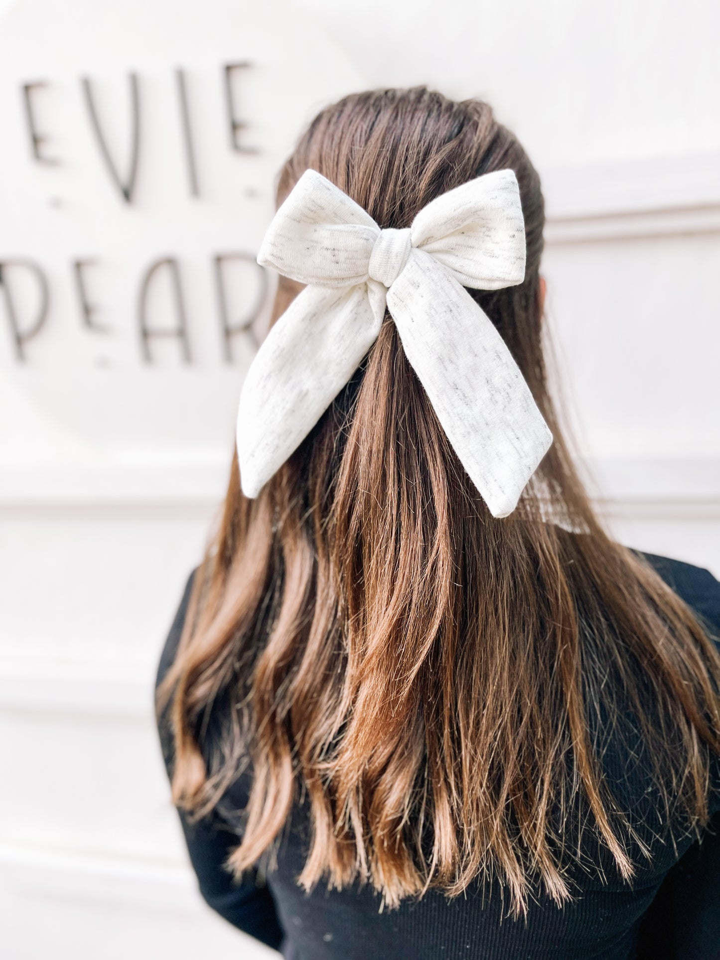 Girl wearing gray sweatshirt longtailed bow cozy neutral hair accessory for toddlers, girls, and women