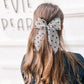 Girl wearing oversized black sheer daisy flocked bow statement hair accessory for toddlers, girls, and women
