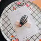 Spooky black skelly hand light pink bow