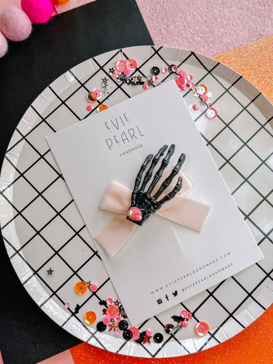 Spooky black skelly hand light pink bow